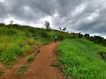 Man riding horse on landscape against sky