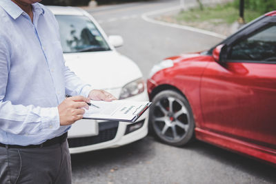 Midsection of man signing insurance document