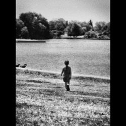 Boy walking on field against sky