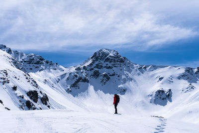 Person skiing on snowcapped mountain against sky