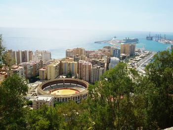 Cityscape by sea against clear sky