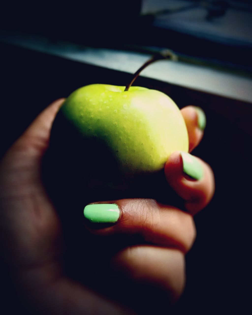 CLOSE-UP OF HAND HOLDING APPLES