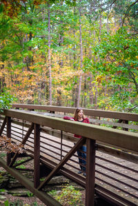 Portrait of a man relaxing on railing in forest