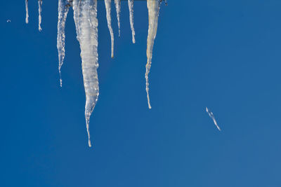 Low angle view of vapor trail against clear blue sky