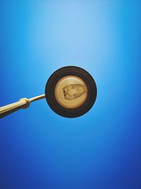 Low angle view of electric lamp against blue sky