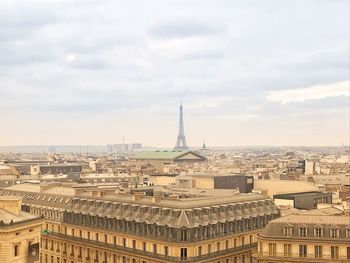 Buildings in city against cloudy sky