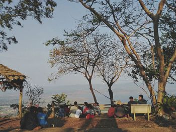 People sitting at park against sky