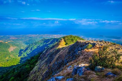 Aerial view of landscape and sea against blue sky