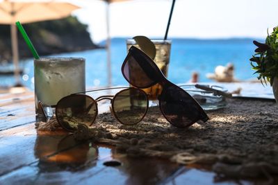 Close-up of sunglasses on table at beach