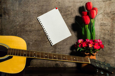 Still life photography with paper notes and guitar.
