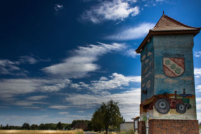 Low angle view of clock tower amidst buildings against sky