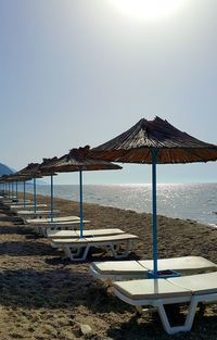 Chairs on beach against clear sky