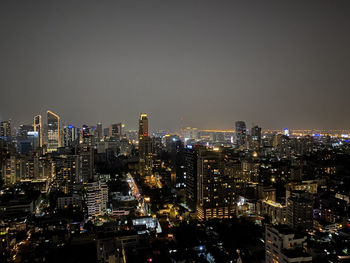 Illuminated buildings in city against sky at night