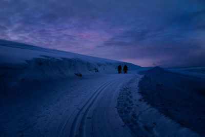 People on snow covered mountain against sky