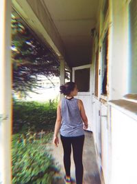 Rear view of woman walking against building