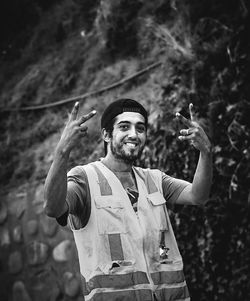 Portrait of young man standing against plants