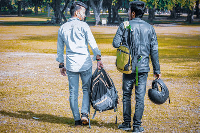 Rear view of people walking on road