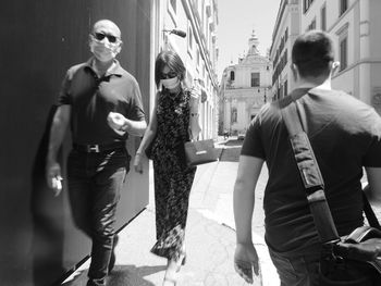 People walking on street against buildings in city