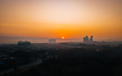 Silhouette buildings against sky during sunset