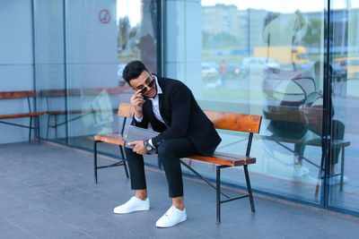 Full length of young man sitting at home