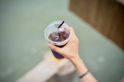 High angle view of woman holding glass of drink