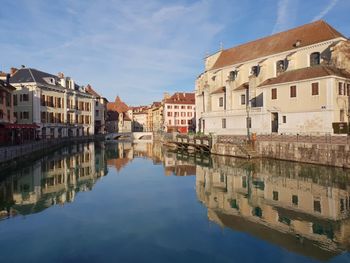 Canal amidst buildings in town against sky