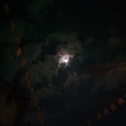 Low angle view of illuminated moon in sky at night