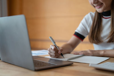 Midsection of businesswoman working on table