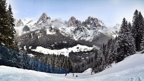 People skiing downhill against mountains