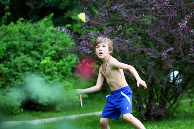 A 7 year old boy plays badminton.