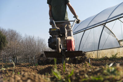 A farmer prepares the ground for the summer vegetable garden with a cutter