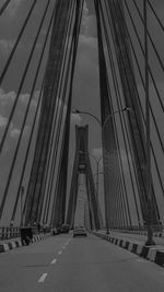 Low angle view of suspension bridge against sky in city