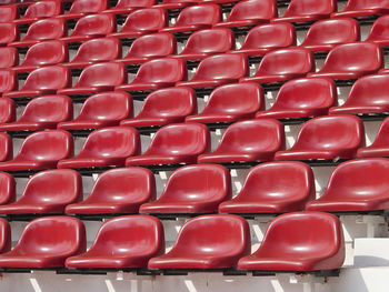 Abstract pattern of red stadium seats in sunlight