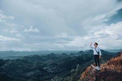 Man standing on mountain against sky