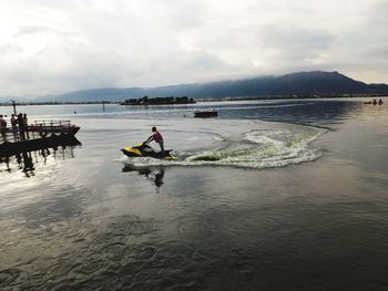 Man in boat on sea against sky