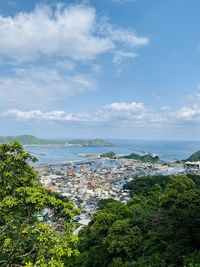 High angle view of townscape by sea against sky