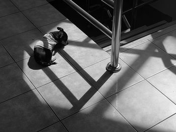 High angle view of man sitting on tiled floor