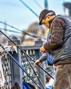 Side view of man standing against railing