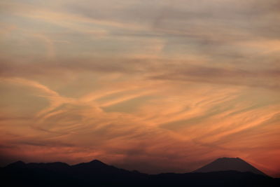 Scenic view of silhouette mountains against romantic sky