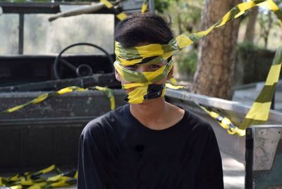 Portrait of young man face wrapped with cordon tape