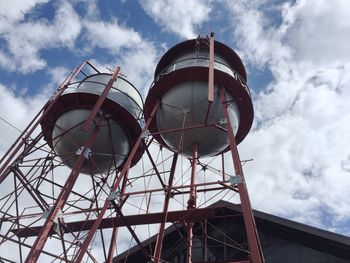 Low angle view of water towers against sky