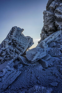 Rock formation against clear blue sky during winter