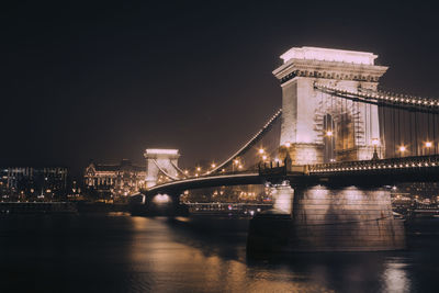 Illuminated bridge over danube river at night