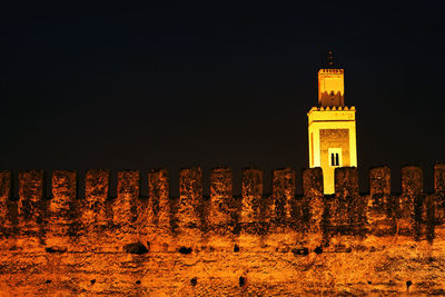 Illuminated building against sky at night