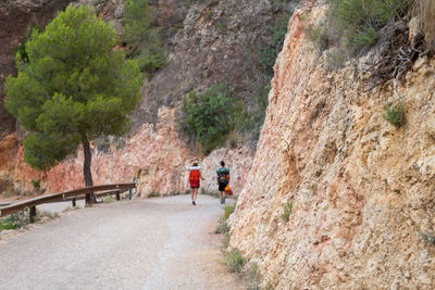 People walking on road amidst rock formation