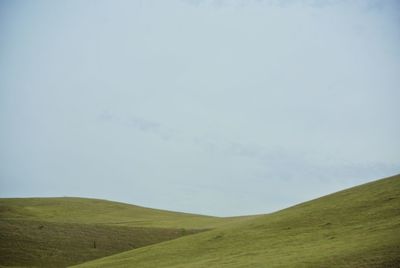 Scenic view of grassy field against cloudy sky