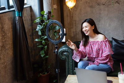 Portrait of young woman sitting at home