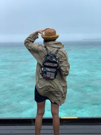 Rear view of man photographing sea against sky