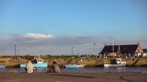 Sailboats moored on sea against sky