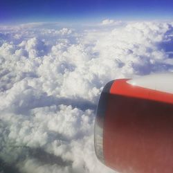 Cropped image of airplane against cloudy sky